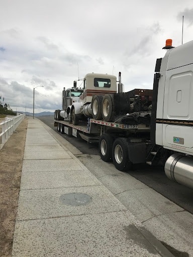 Semi trucks on step deck trailer